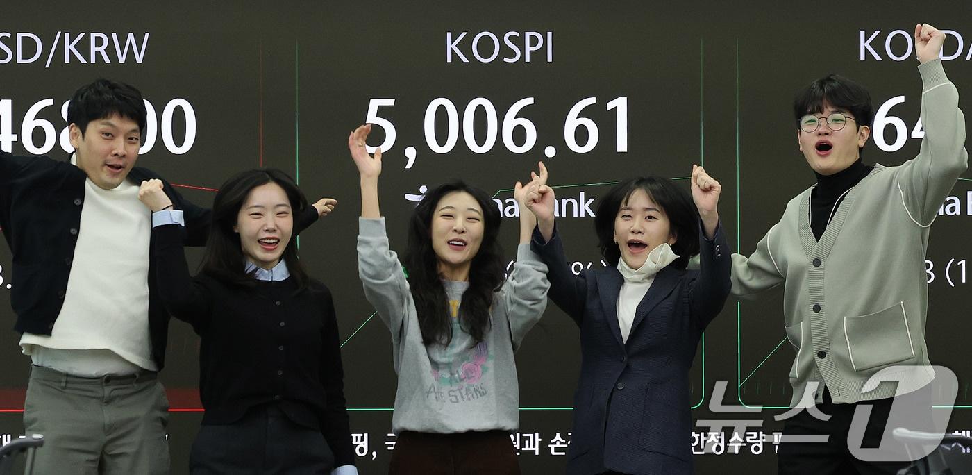 본문 이미지 - 22일 오전 서울 중구 하나은행 본점 딜링룸 현황판에 코스피 지수가 장중 5000p를 넘으며 개장하자 직원들이 환호하고 있다. 2026.1.22/뉴스1 ⓒ News1 박지혜 기자