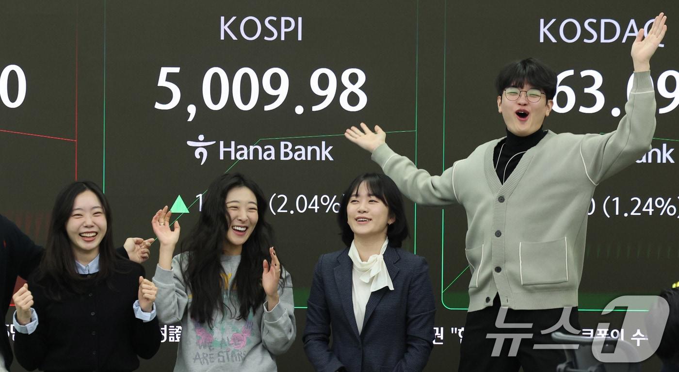 본문 이미지 - 22일 오전 서울 중구 하나은행 본점 딜링룸 현황판에 코스피 지수가 장중 5000p를 넘으며 개장하자 직원들이 환호하고 있다. 2026.1.22/뉴스1 ⓒ News1 박지혜 기자