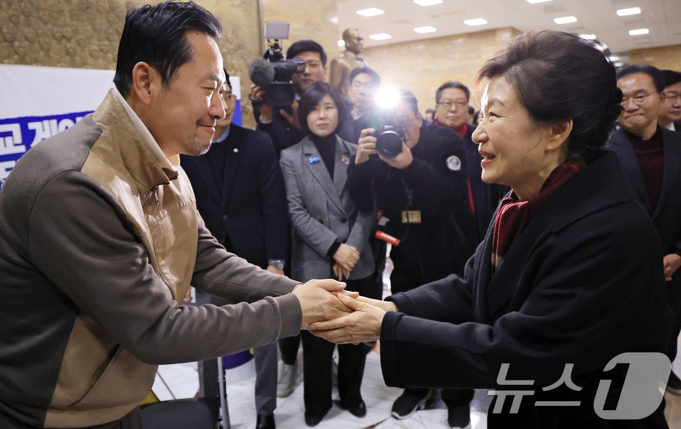 본문 이미지 - 박근혜 전 대통령이 22일 서울 여의도 국회 로텐더홀에서 통일교·공천헌금 '쌍특검' 수용을 요구하며 8일째 단식 중인 국민의힘 장동혁 대표를 찾아 인사를 나누고 있다. 2026.1.22/뉴스1 ⓒ News1 국회사진기자단