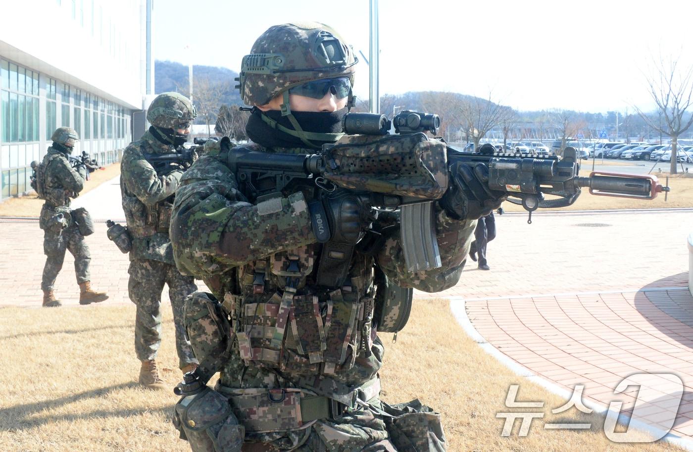 본문 이미지 - 육군 35사단 충무여단 장병들이 22일 전북 전주시 농촌진흥청 농업유전자원센터에서 혹한기 전술훈련의 일환으로 실시된 민·관·군·경·소방 등 통합방위 훈련에서 사주경계를 하고 있다. 2026.1.22/뉴스1 ⓒ News1 유경석 기자