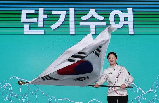 본문 이미지 - 이수경 선수단장이 22일 서울 송파구 올림픽파크텔에서 열린 2026 밀라노코르티나 동계올림픽대회 결단식에서 유승민 대한체육회장에게 수여받은 단기를 흔들고 있다. 2026.1.22/뉴스1 ⓒ News1 김성진 기자