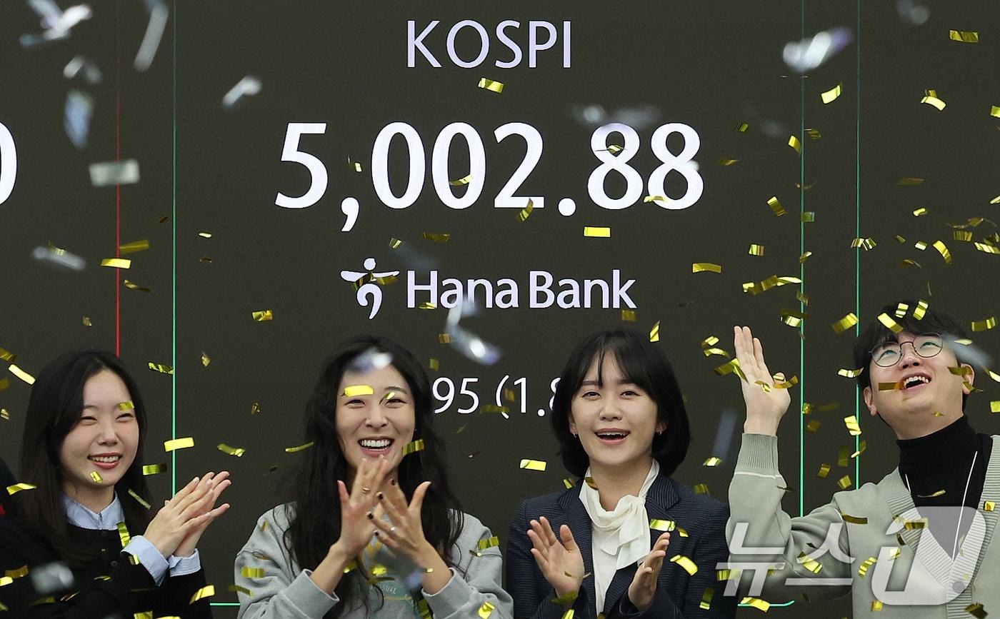 본문 이미지 - 코스피지수가 사상 처음으로 장중 5000을 돌파한 22일 오전 서울 을지로 하나은행 딜링룸에서 직원들이 신기록 달성을 축하하고 있다. 이날 코스피지수는 한때 5019.54까지 상승했다가 0.87% 오른 4952.53에 거래를 마쳤다. 2026.1.22/뉴스1 ⓒ News1 박지혜 기자