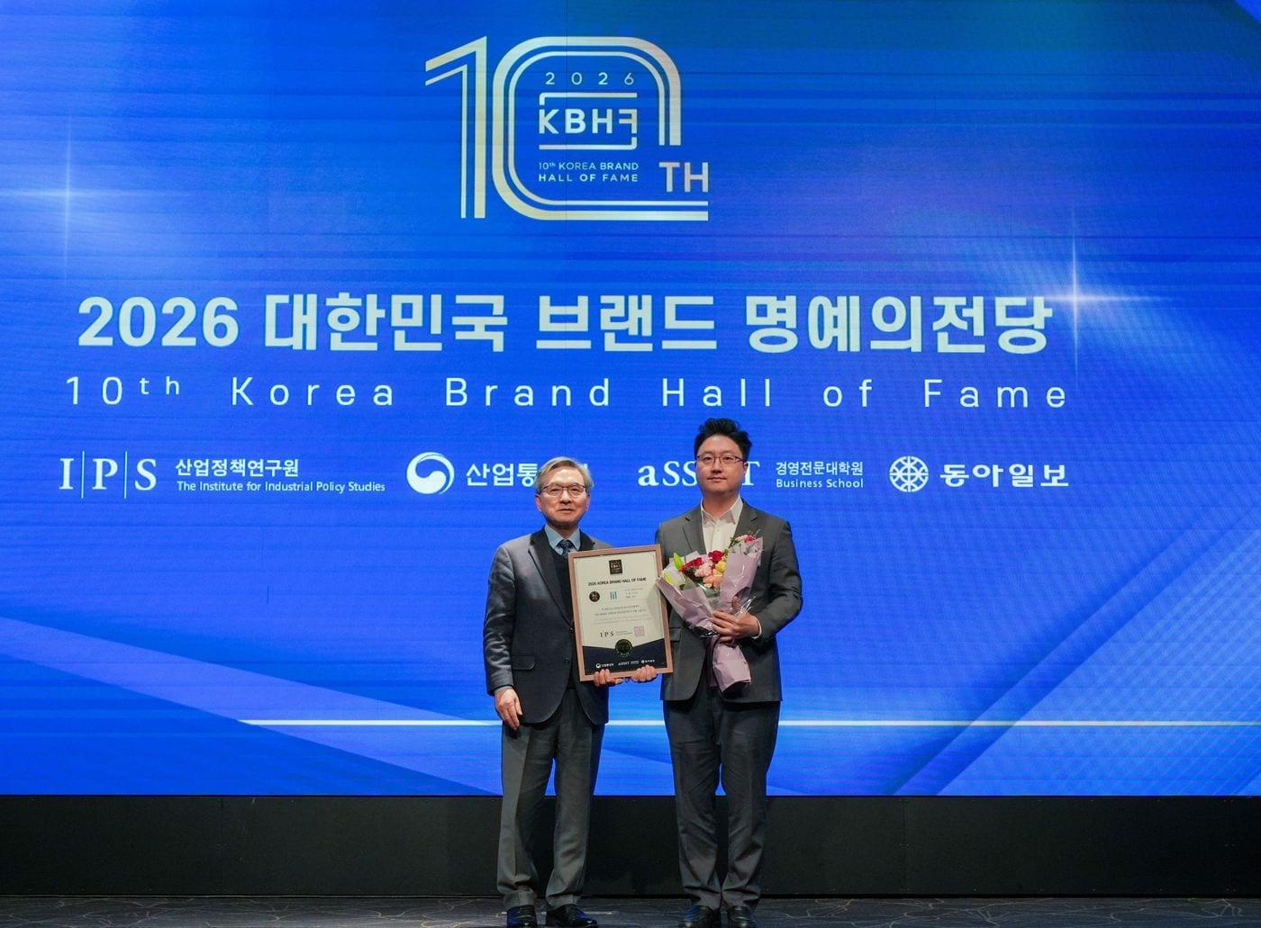 본문 이미지 - KT&G의 ‘릴(lil)’이 ‘2026 대한민국 브랜드 명예의 전당’ 궐련형 전자담배 부문 우수 브랜드로 8년 연속 선정됐다. 사진은 지난 22일 김정훈 KT&G NGP사업본부 국내플랫폼팀장(오른쪽)이 표정호 서울과학종합대학원대학교 부총장(왼쪽)과 기념사진 촬영을 하고 있는 모습.(KT&G 제공)