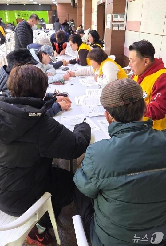 본문 이미지 - 충북 옥천군 옥천읍행정복지센터에 설치한  농어촌 기본소득 창구를 찾은 주민들이 신청서를 작성하고 있다. (재판매 및 DB금지) /뉴스1