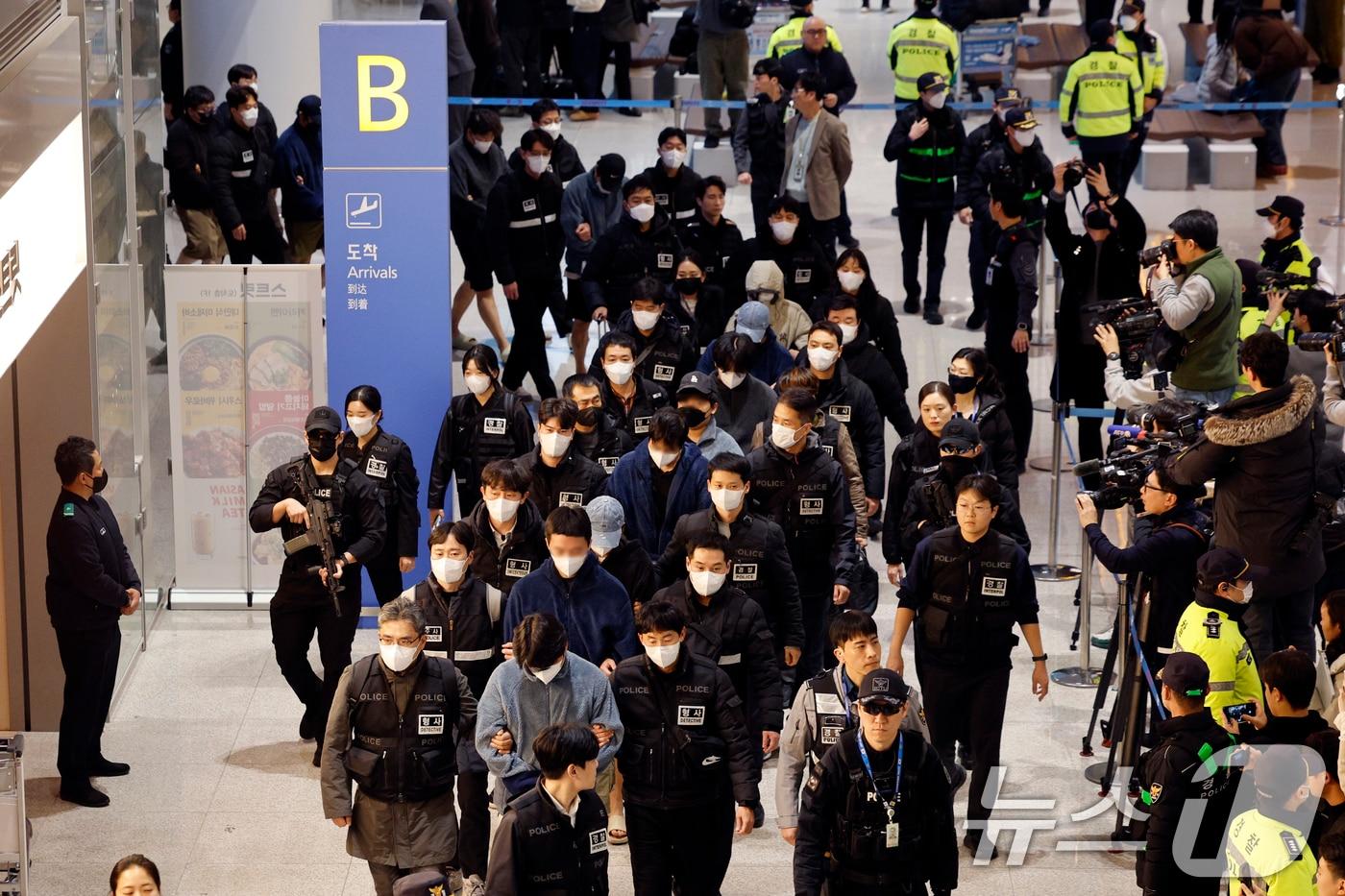 본문 이미지 - 캄보디아를 거점으로 대규모 스캠 범죄를 저지른 한국 국적 피의자 73명이 23일 오전 인천국제공항 2터미널을 통해 강제 송환되고 있다.  ⓒ News1 안은나 기자