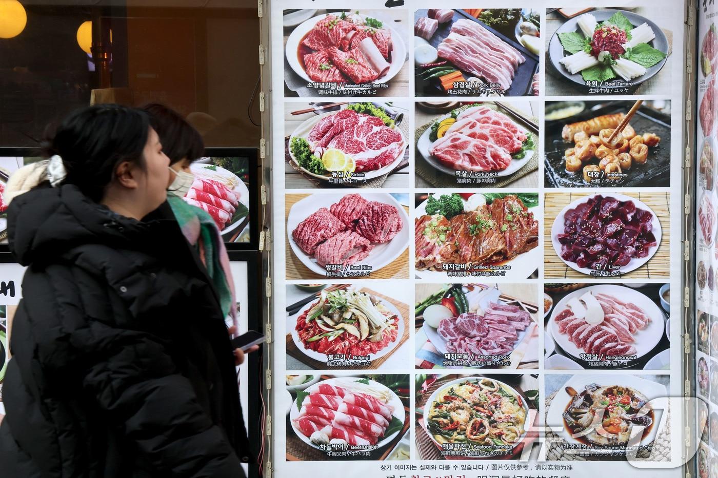 본문 이미지 - 23일 서울 중구 명동에서 시민들이 한식당 앞을 지나가고 있다.  2026.1.23 ⓒ 뉴스1 이광호 기자