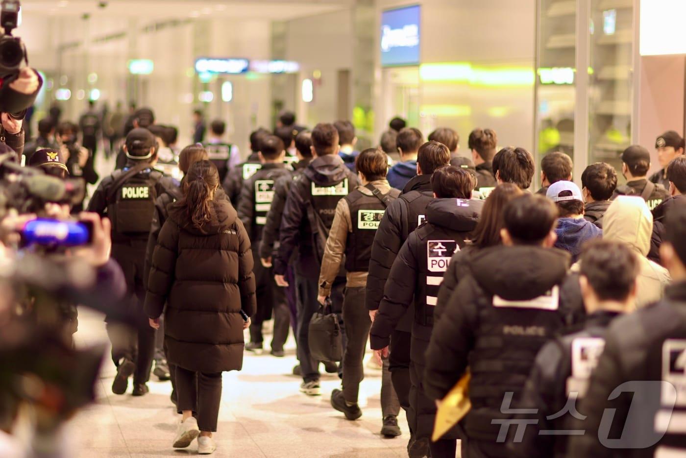 본문 이미지 - 캄보디아를 거점으로 대규모 스캠 범죄를 저지른 한국 국적 피의자 73명이 23일 오전 인천국제공항 2터미널을 통해 강제 송환되고 있다. (부산경찰청 제공. 재판매 및 DB 금지) 2026.1.23/뉴스1 ⓒ News1 윤일지 기자