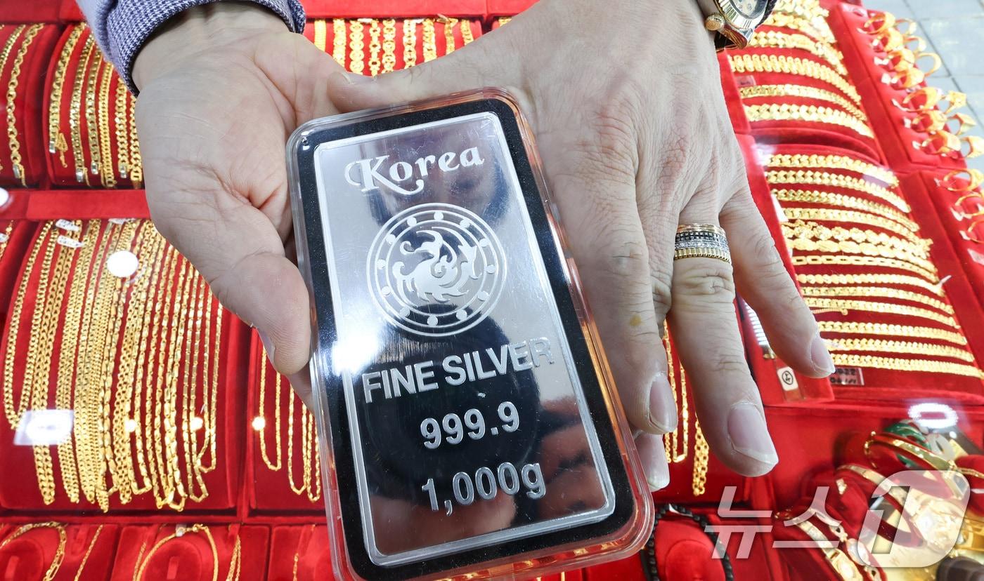 본문 이미지 - 금·은 가격이 연일 고공행진하는 23일 서울 종로구 한 금은방에서 직원이 실버바를 정리하고 있다. 14시 24분 기준 현물기준 금 국제 시세는 온스당 4천958.29달러, 은 시세는 98.67달러를 기록중이다. 2026.1.23/뉴스1 ⓒ News1 최지환 기자