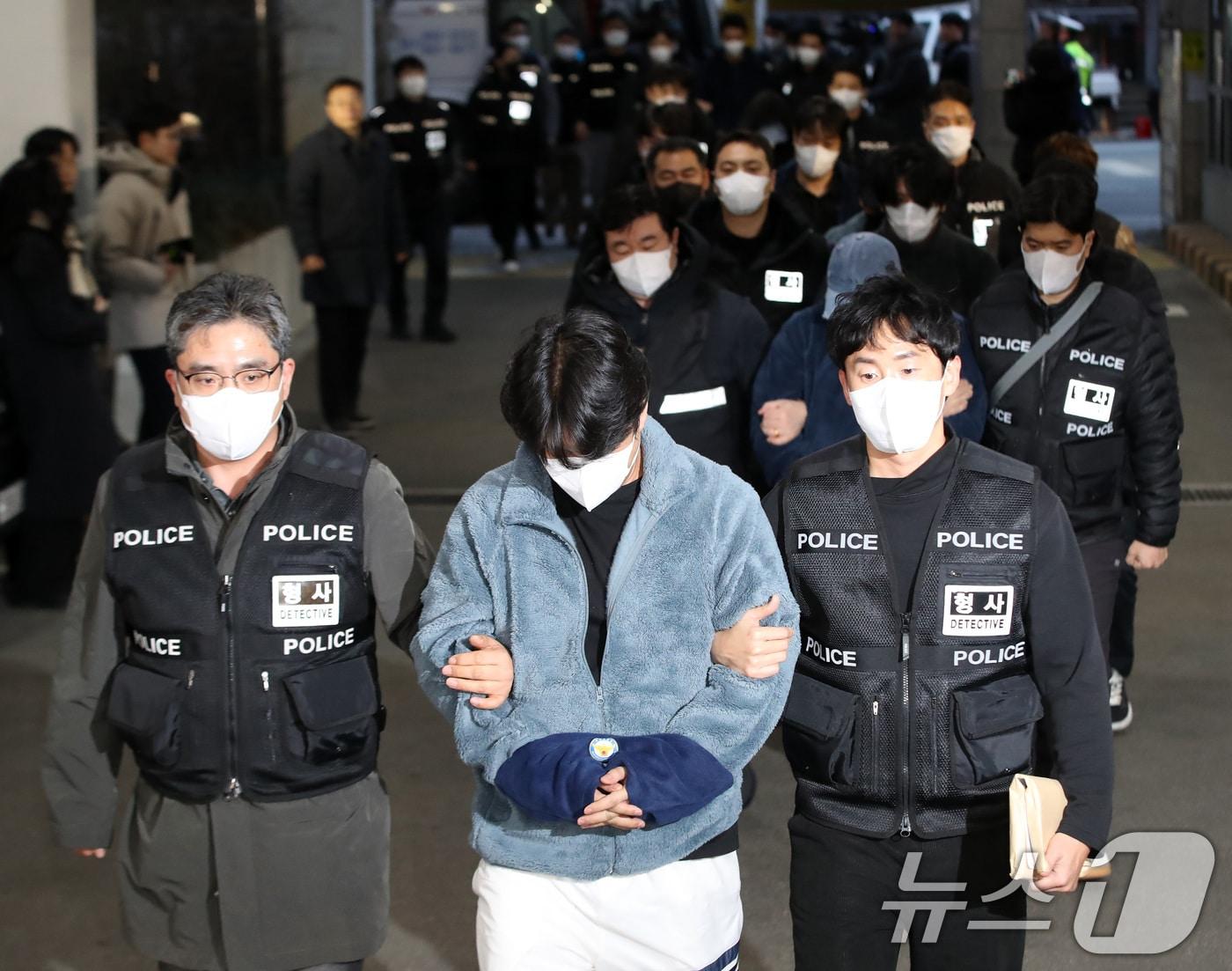 본문 이미지 - 캄보디아에서 대규모 스캠 범죄를 저질러 강제 송환된 한국인 피의자들이 23일 오후 부산 동래구 동래경찰서로 압송되고 있다.  2026.1.23/뉴스1 ⓒ News1 윤일지 기자