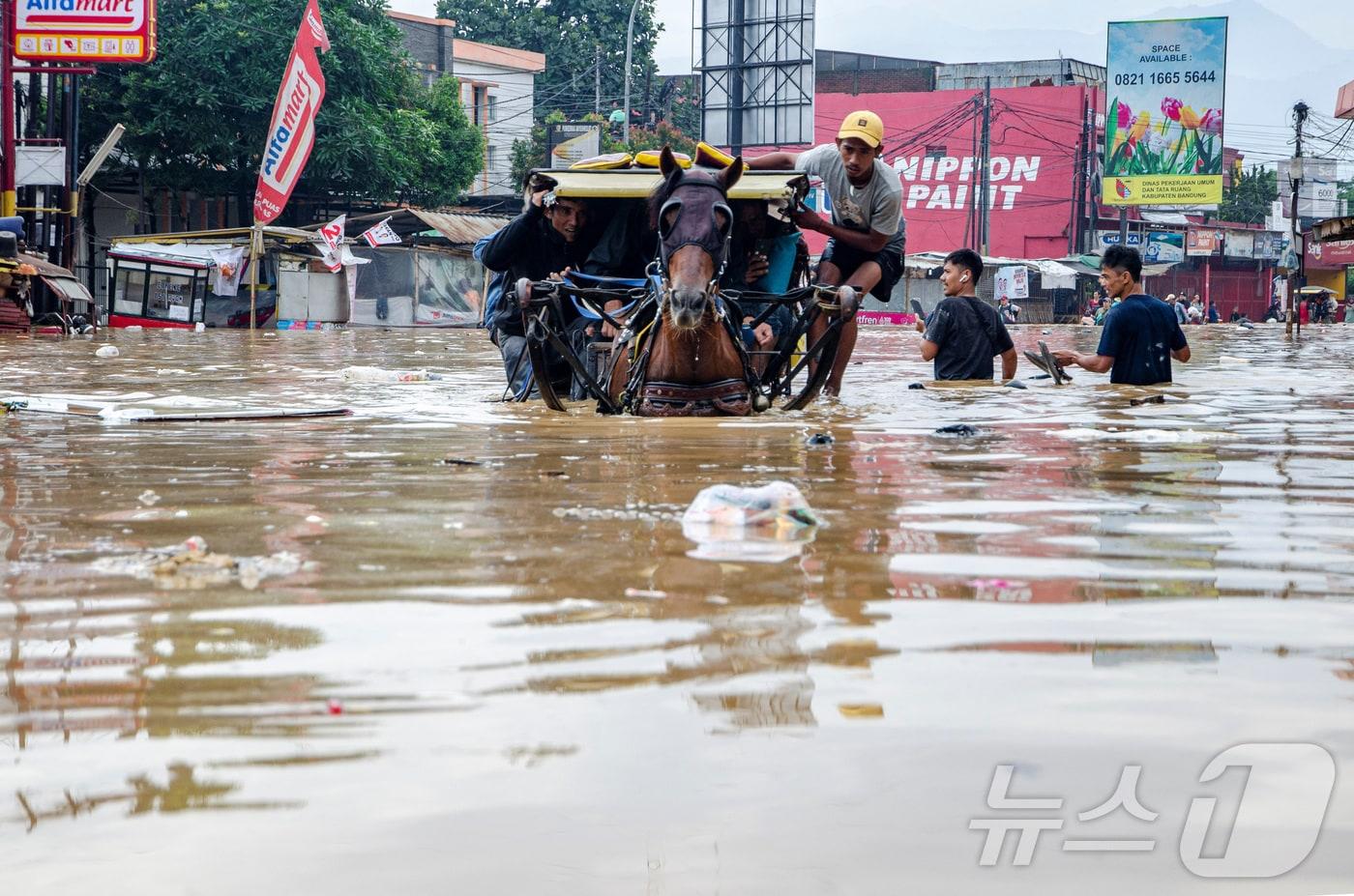 본문 이미지 - 지난 2024년 1월 12일 인도네시아 서자바주 반둥 지역에서 홍수로 인해 거리가 침수된 모습. 2024.01.12 ⓒ 로이터=뉴스1 ⓒ News1 김지완 기자