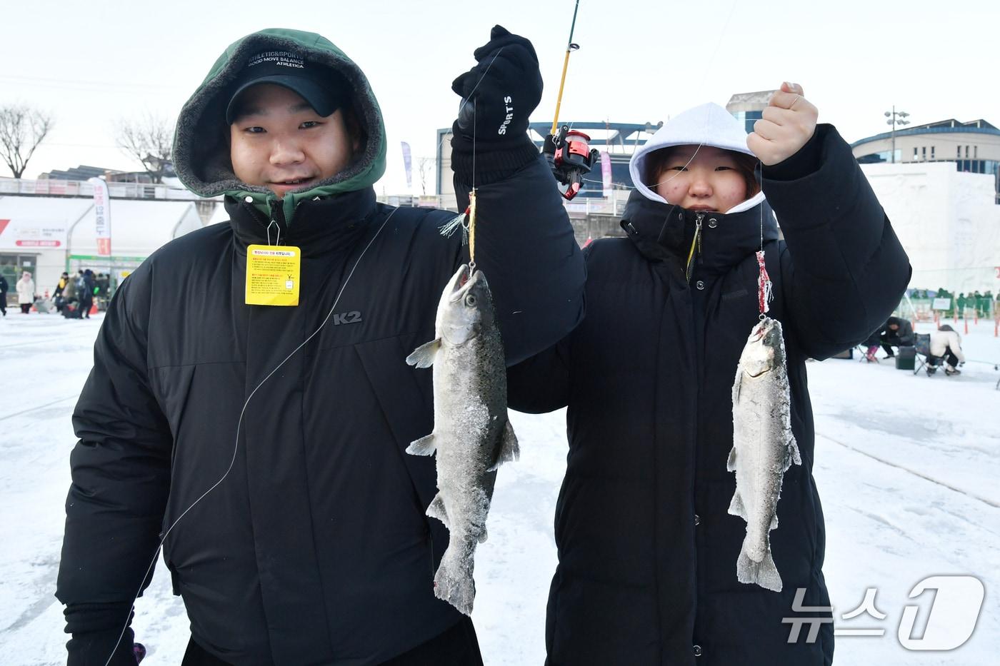본문 이미지 - 강원의 대표 축제 중 하나인 '2026 얼음나라 화천산천어축제'가 지난 10일 개막해 약 100만 인파와 함께 흥행을 누리고 있는 가운데, 24일 축제 방문객들이 잡은 물고기를 뽐내고 있다. (화천군 제공. 재판매 및 DB금지) 2026.1.24/뉴스1