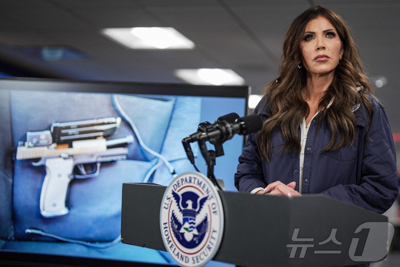 본문 이미지 - 크리스티 놈 국토안보부 장관이 24일(현지시간) 미네소타주 미니애폴리스에서 발생한 총격 사건 이후 기자회견을 통해 이민 요원들이 회수한 권총 사진을 공개하고 있다. 2026.1.24 ⓒ AFP=뉴스1 ⓒ News1 김경민 기자