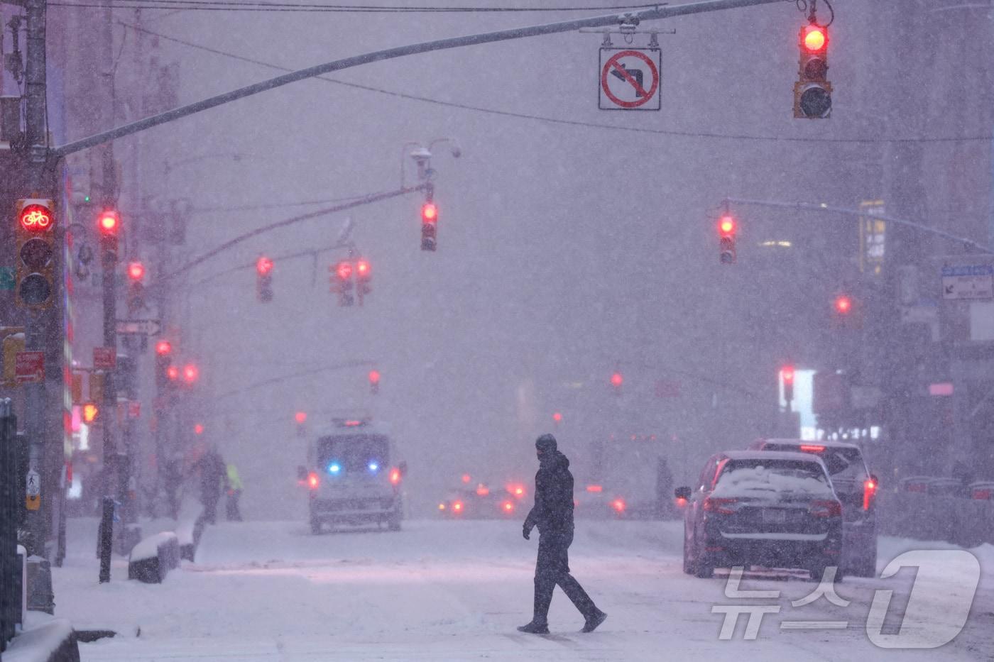 본문 이미지 - 25일(현지시간) 미국 전역에 겨울 눈폭풍이 몰아친 가운데 한 남성이 뉴욕 타임스퀘어 인근 도로를 건너고 있다. 2026.01.25. ⓒ 로이터=뉴스1 ⓒ News1 류정민 특파원