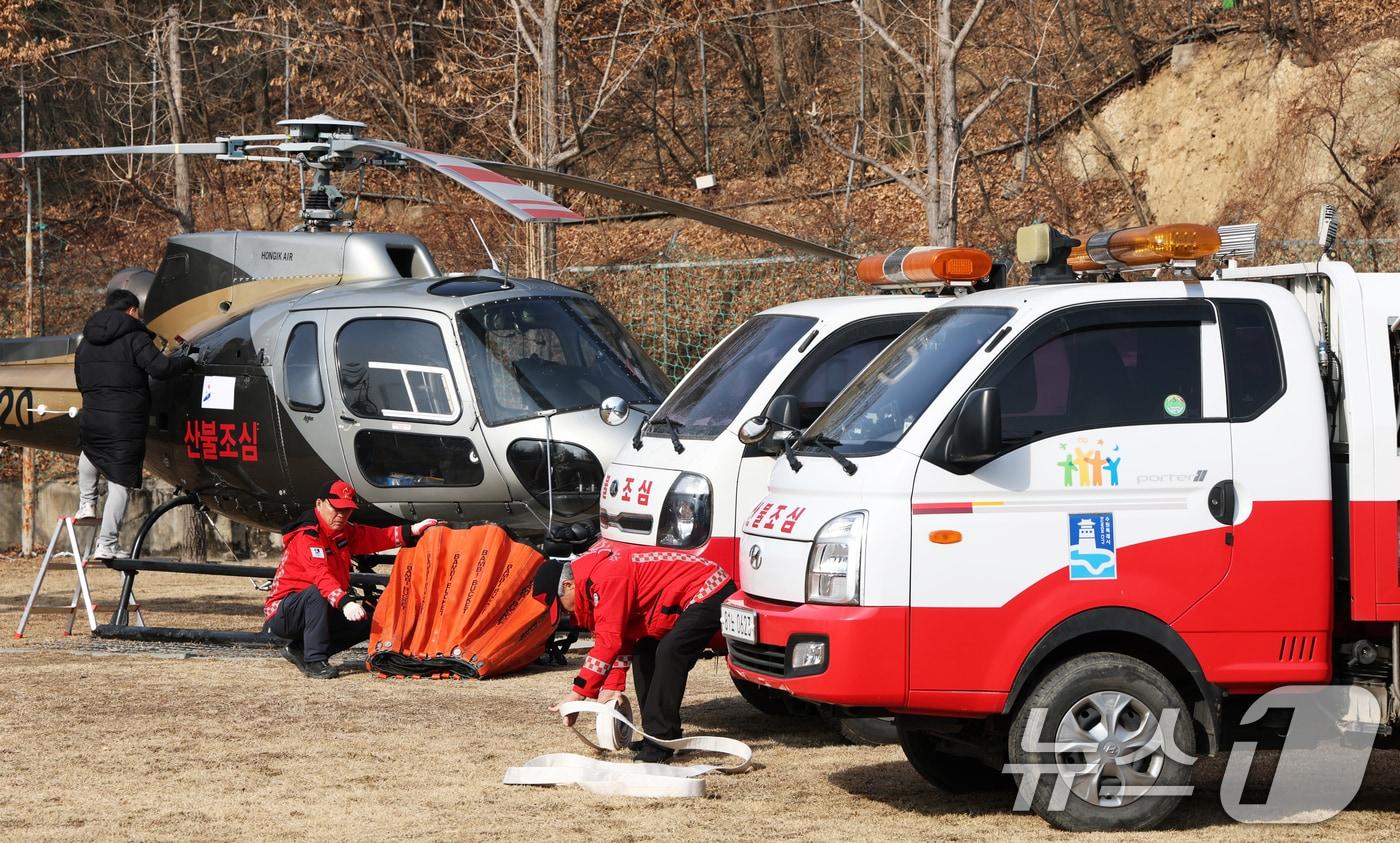 본문 이미지 - 전국 곳곳에 건조특보가 발효된 가운데 바람까지 강하게 불고 있는 26일 경기 수원시 장안구 산불진화헬기 임시계류장에서 수원시 산불감시원과 헬기 정비사가 다목적 산불진화차량 및 산불 대응 헬기를 점검하고 있다 2026.1.26/뉴스1 ⓒ News1 김영운 기자