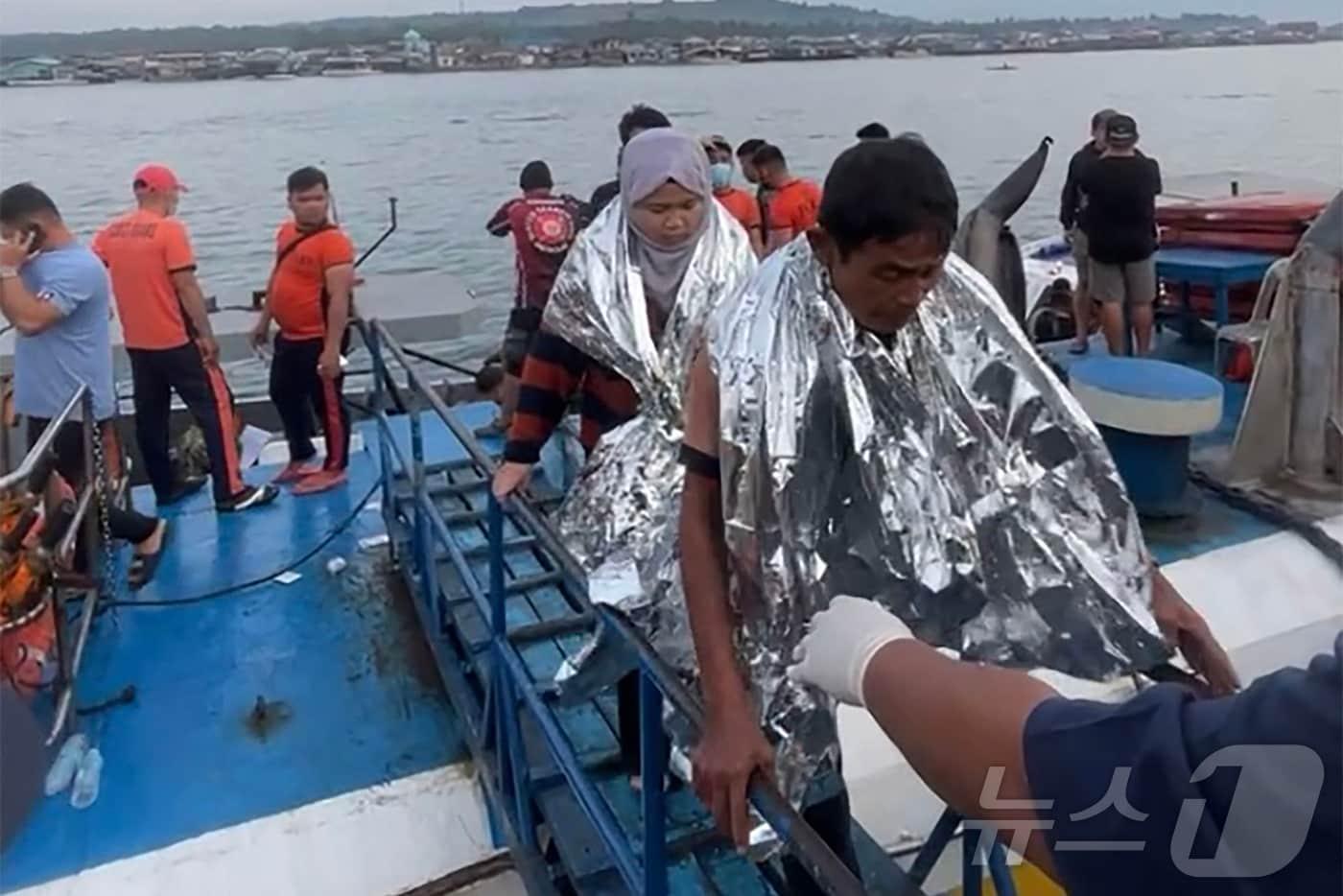 본문 이미지 - 26일(현지시간) 필리핀 해안경비대원들이 바실란주 인근 해역에서 침몰한 여객선 M/V 트리샤 커스틴 3호 구조자들을 보살피고 있다. 2026.01.26. ⓒ AFP=뉴스1 ⓒ News1 윤다정 기자