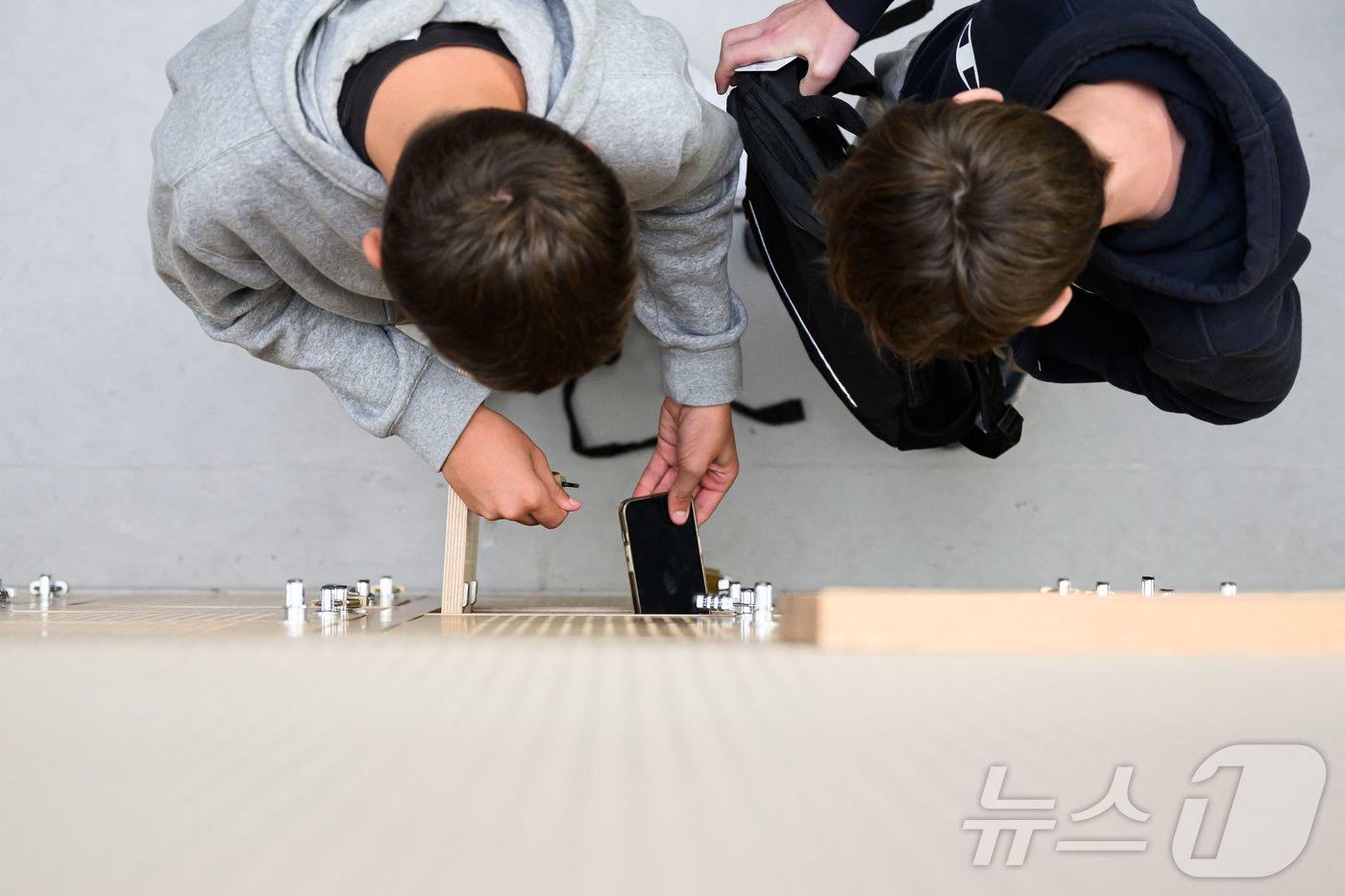 본문 이미지 - 프랑스 서부 로리앙의 오귀스트 브리죄 고등학교에서 학생들이 휴대전화를 끈 뒤 사물함에 넣고 있다. 2024.9.5./뉴스1 ⓒ AFP=뉴스1 ⓒ News1 이창규 기자