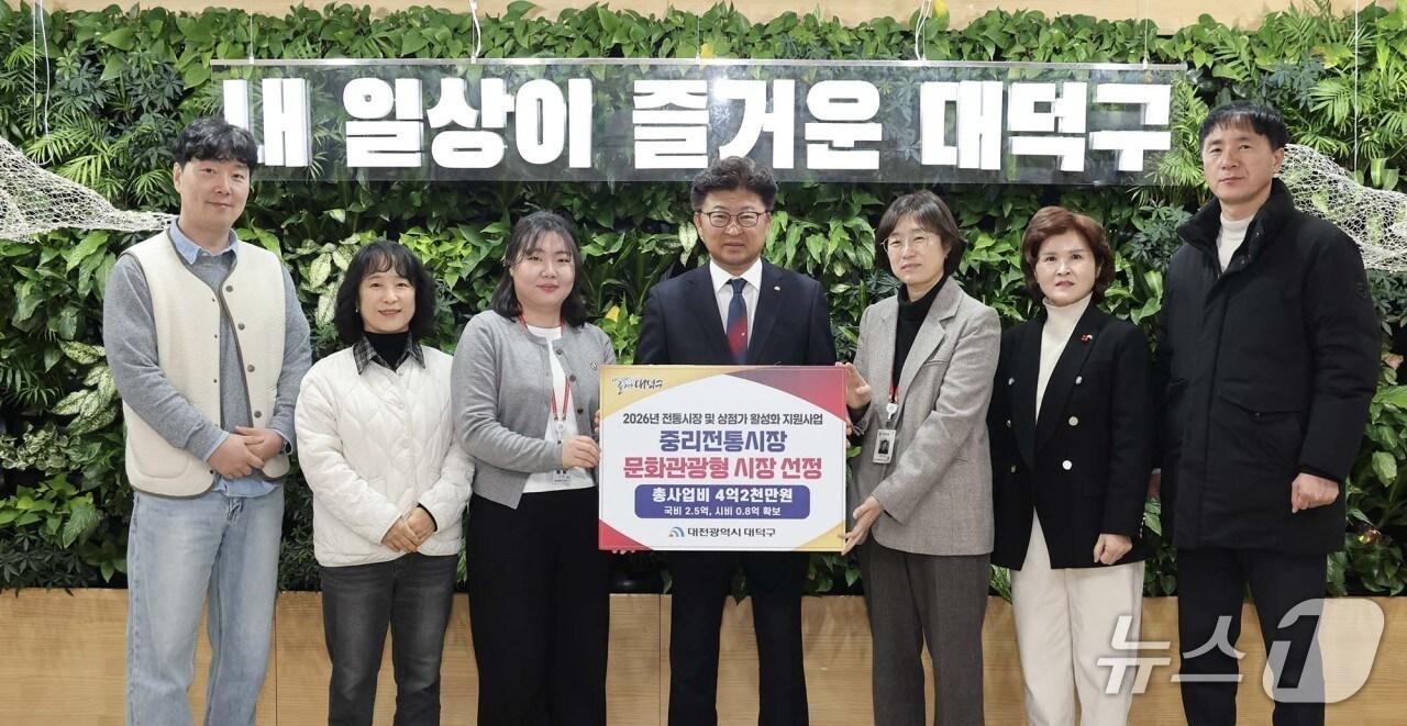 본문 이미지 - 최충규 대덕구청장(사진 가운데)과 대덕구 직원들이 중리전통시장의 ‘2026년 전통시장 특성화(문화관광형) 육성사업’공모 선정 후 기념 촬영을 하고 있다.(대덕구 제공. 재판매 및 DB금지)/뉴스1