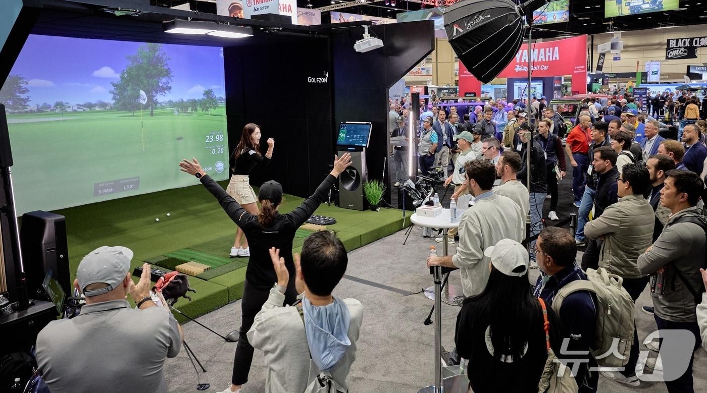 본문 이미지 - 2026 PGA쇼에서 GTOUR에서 활약 중인 한국의 안예인 프로가 골프존 부스에 모인 많은 외국인 관람객들 앞에서 버디를 성공시키고 환호하고 있다 (골프존 제공)
