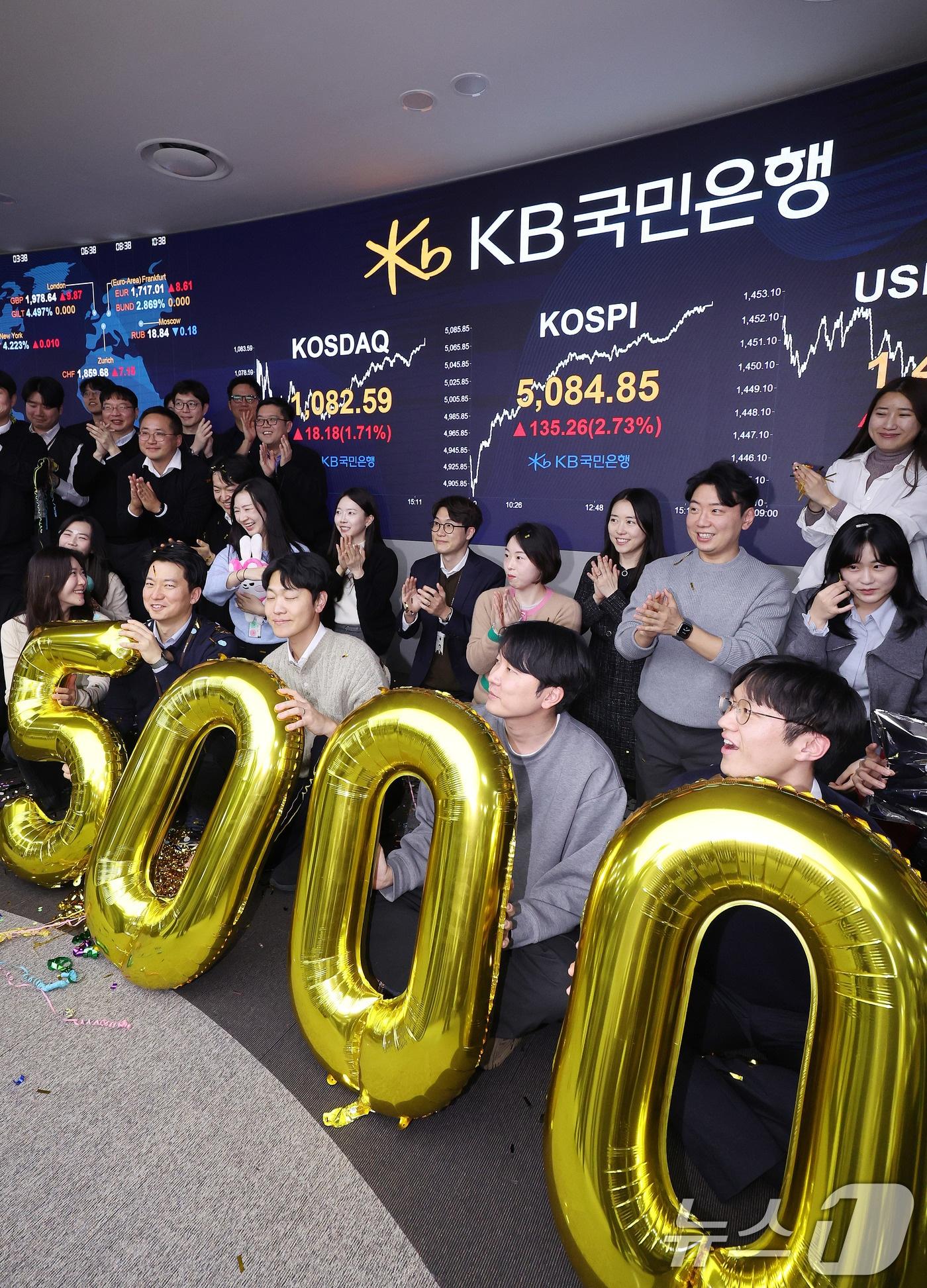 본문 이미지 - 코스피가 종가 기준 사상 처음 5000선을 돌파한 27일 오후 서울 영등포구 KB국민은행 딜링룸에서 직원들이 축하 세리머니를 하고 있다. 이날 코스피지수는 전일대비 135.26p(2.73%) 오른 5084.85로 장을 마감했다. 2026.1.27/뉴스1 ⓒ News1 박지혜 기자