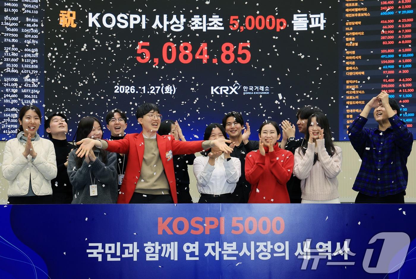 본문 이미지 - 한국 증시 최초로 종가 기준 코스피 5000을 달성한 27일 서울 영등포구 한국거래소에서 직원들이 코스피 종가가 표시된 전광판을 배경으로 세레머니를 하고 있다. ⓒ News1 이호윤 기자