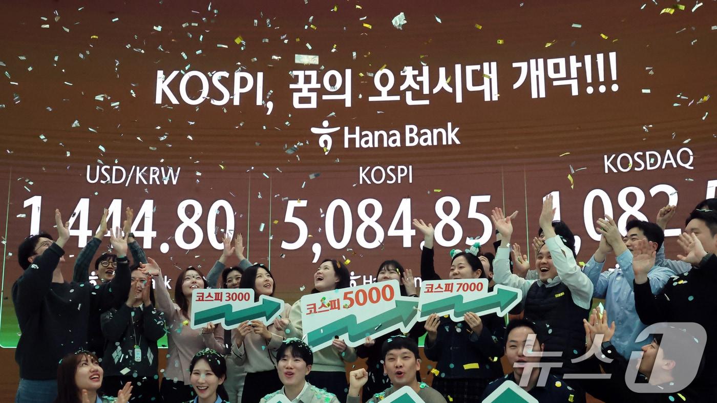 본문 이미지 - 코스피가 종가 기준 사상 처음 5000선을 돌파한 27일 오후 서울 중구 하나은행 본점 딜링룸에서 직원들이 축하 세리머니를 하고 있다. 이날 코스피지수는 전일대비 135.26p(2.73%) 오른 5084.85로 장을 마감했다. 2026.1.27/뉴스1 ⓒ News1 황기선 기자