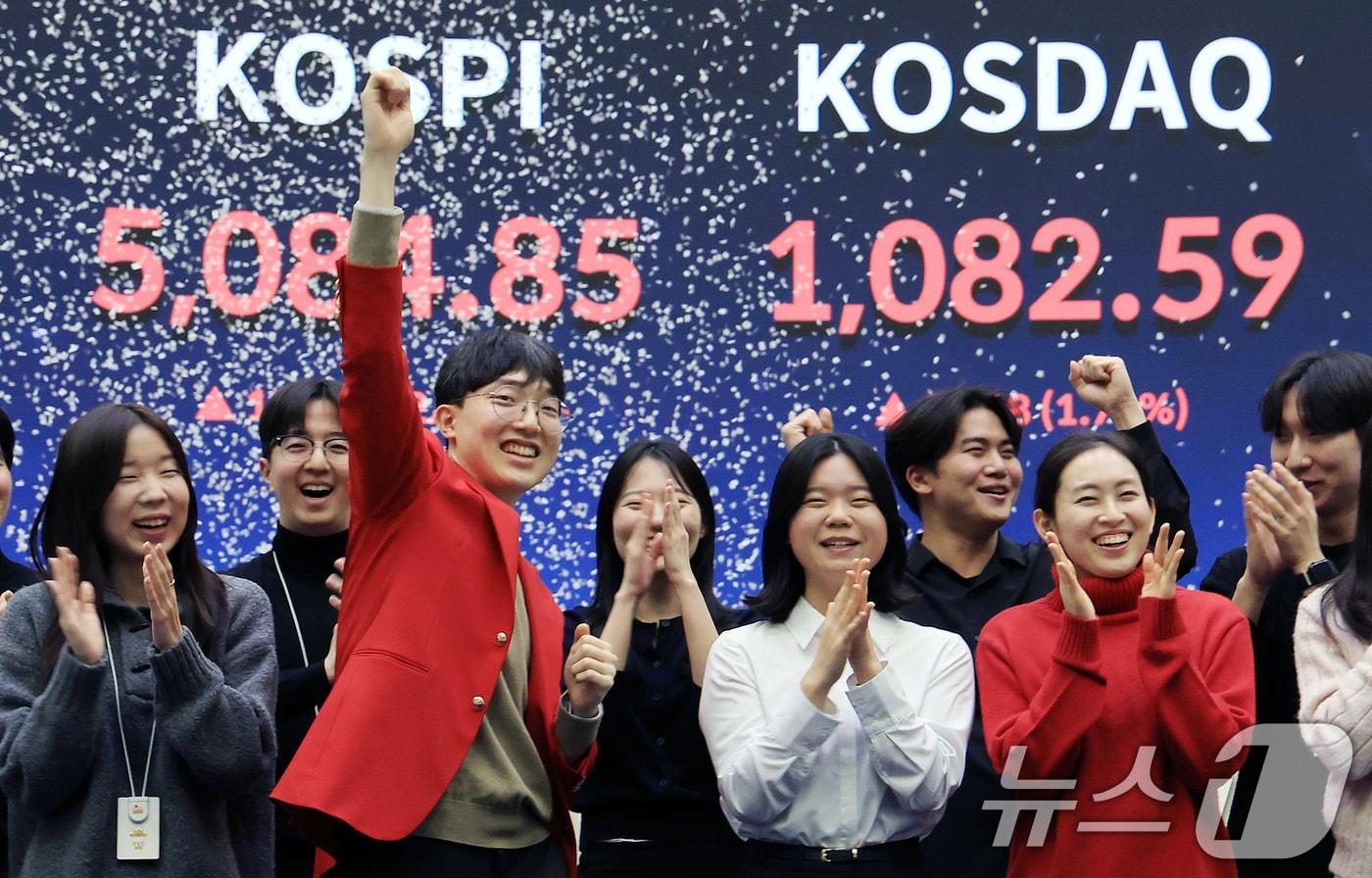 본문 이미지 - 한국 증시 최초로 종가 기준 코스피 5000을 달성한 27일 서울 영등포구 한국거래소에서 직원들이 코스피 종가가 표시된 전광판을 배경으로 세레머니를 하고 있다. 이날 코스피지수는 전일대비 135.26p(2.73%) 오른 5084.85로 장을 마감했다. 2026.1.27/뉴스1 ⓒ News1 이호윤 기자