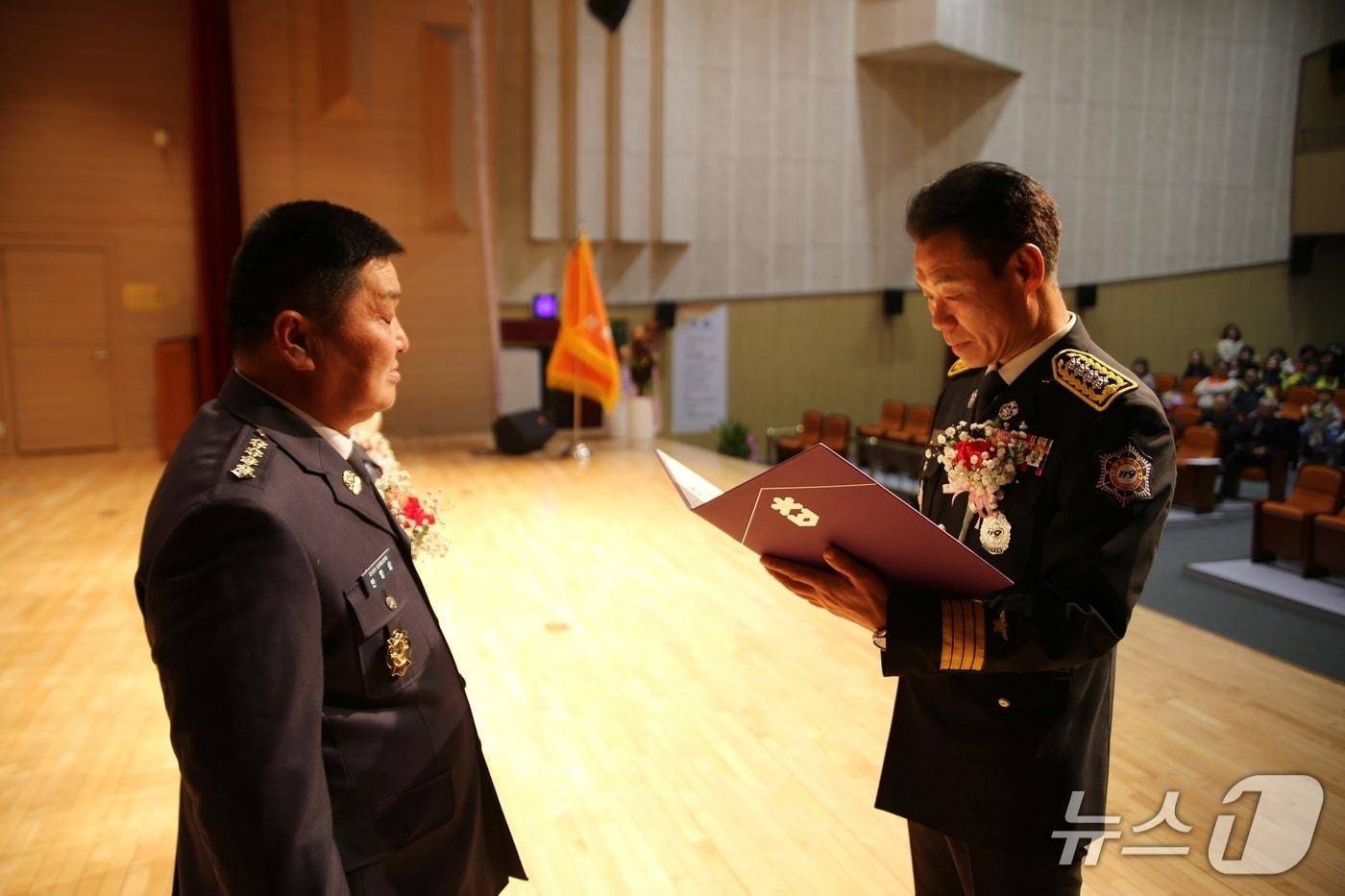 본문 이미지 - 27일 충북 괴산문화예술회관에서 열린 괴산군 의용소방대장 합동 이·취임식에서 양찬모 괴산소방서장이 안영삼 괴산남성의용소방대장(왼쪽)에게 임명장을 주고 있다.(괴산소방서 제공, 재판매 및 DB금지)/뉴스1