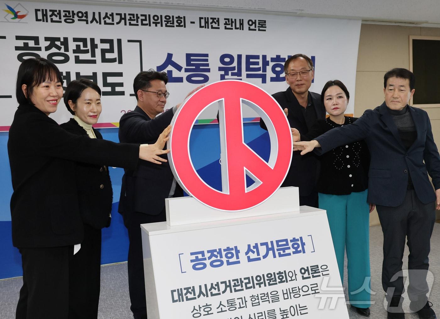 본문 이미지 - 제9회 전국동시지방선거를 앞두고 28일 대전시선거관리위원회에서 열린 ‘공정관리·공정보도 소통 원탁회의’에 앞서 참석자들이 공정한 선거문화를 함께 만들어 가겠다는 공동 메시지 퍼포먼스를 하고 있다. 2026.1.28 ⓒ 뉴스1 김기태 기자