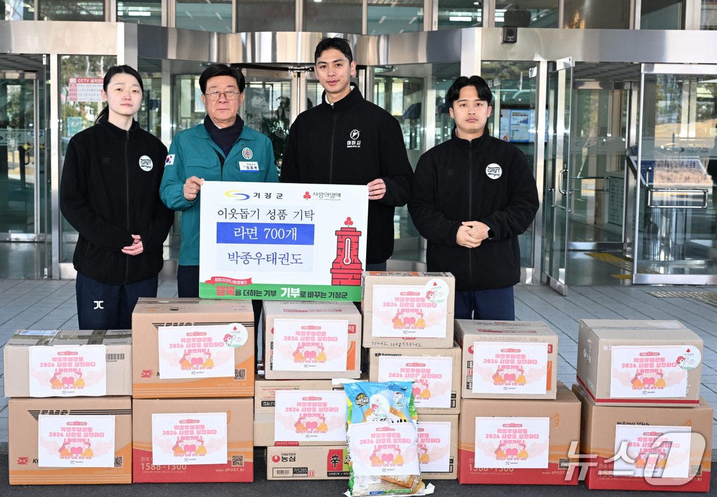 본문 이미지 - 정종복 기장군수(왼쪽 두 번째)와 박종우 태권도관장(오른쪽 두 번째)이 성품 기탁식 후 기념촬영을 하고 있다.(기장군 제공. 재판매 및 DB금지)