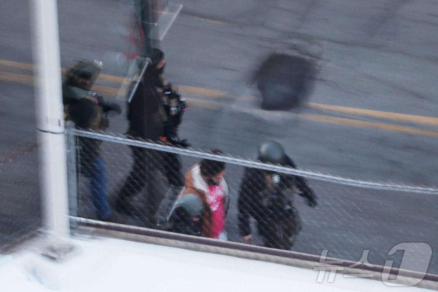 본문 이미지 - 28일(현지시간) 미국 미네소타주 미니애폴리스의 한 아파트 건물에서 연방 이민 단속 요원들이 사람을 구금하고 있다. 2026.01.28. ⓒ 로이터=뉴스1 ⓒ News1 윤다정 기자