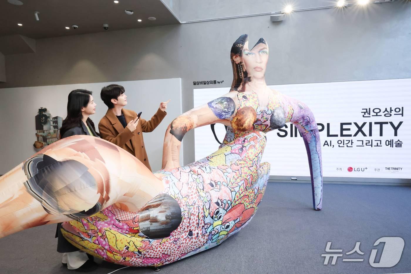 본문 이미지 - '일상비일상의틈 by U+'에서 관람객들이 익시오 AI 도슨트를 이용해 권오상 작가의 전시를 감상하고 있는 모습. 2026.01.29/뉴스1(LG유플러스 제공)