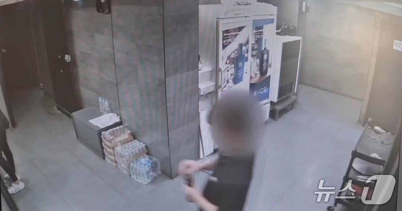 본문 이미지 - A 씨와 B 씨가 공동으로 운영하는 주점에서 직원이 가짜 양주병 뚜껑 부분을 손으로 가린 채 서빙하고 있다.(부산지검 제공 CCTV 영상 갈무리. 재판매 및 DB 금지)