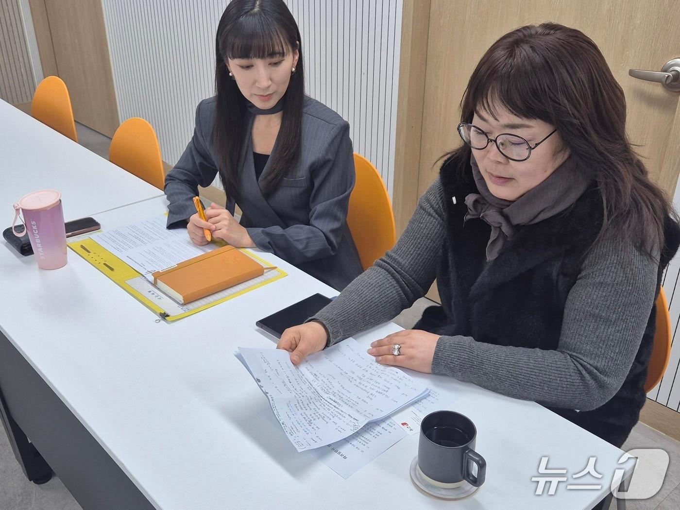 본문 이미지 - 희귀질환자 쉼터를 이용하는 최성미 씨(오른쪽)와 김진화 부장이 기자와 인터뷰하고 있다. 최 씨 손에 들린 종이에 그간 진료 이력이 빼곡히 적혀있다. 2026.1.29/뉴스1 조유리 기자