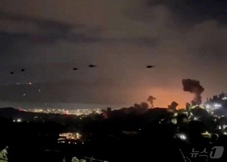 본문 이미지 - 3일(현지시간) 베네수엘라 수도 카라카스 상공에서 헬기들이 폭발로 인해 피어오르는 연기 기둥을 지나쳐 비행하고 있다. 2025.1.3 ⓒ 로이터=뉴스1 ⓒ News1 김성진 기자