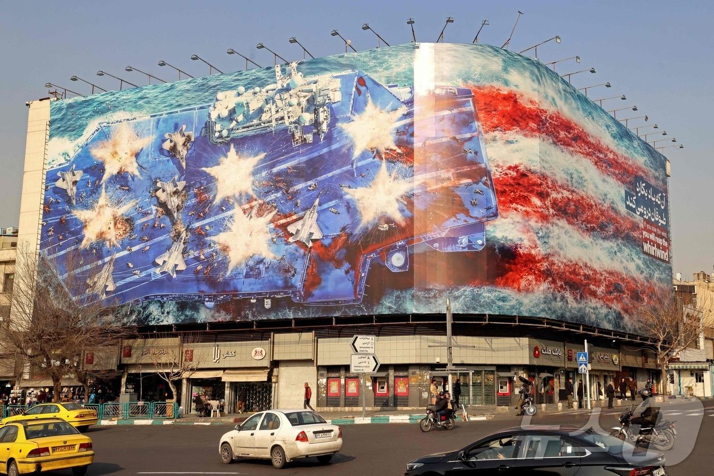 본문 이미지 -  26일(현지시간) 이란 테헤란 엔켈랍 광장의 한 건물에 설치된 반미 광고판 앞을 차량들이 지나가고 있다. 2026.01.26. ⓒ AFP=뉴스1 ⓒ News1 이정환 기자