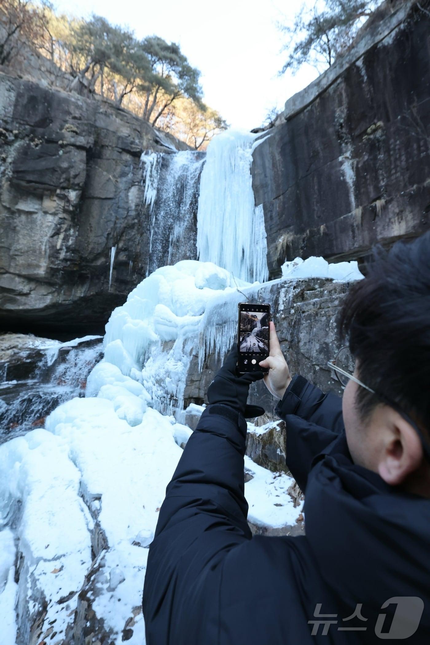 본문 이미지 - 30일 충북 괴산군 연풍면 수옥폭포가 최근 이어진 맹추위로 거대한 빙폭으로 변해 관광객이 겨울장관을 촬영하고 있다.(괴산군 제공. 재판매 및 DB 금지) 2026.1.30/뉴스1 ⓒ News1 이성기 기자