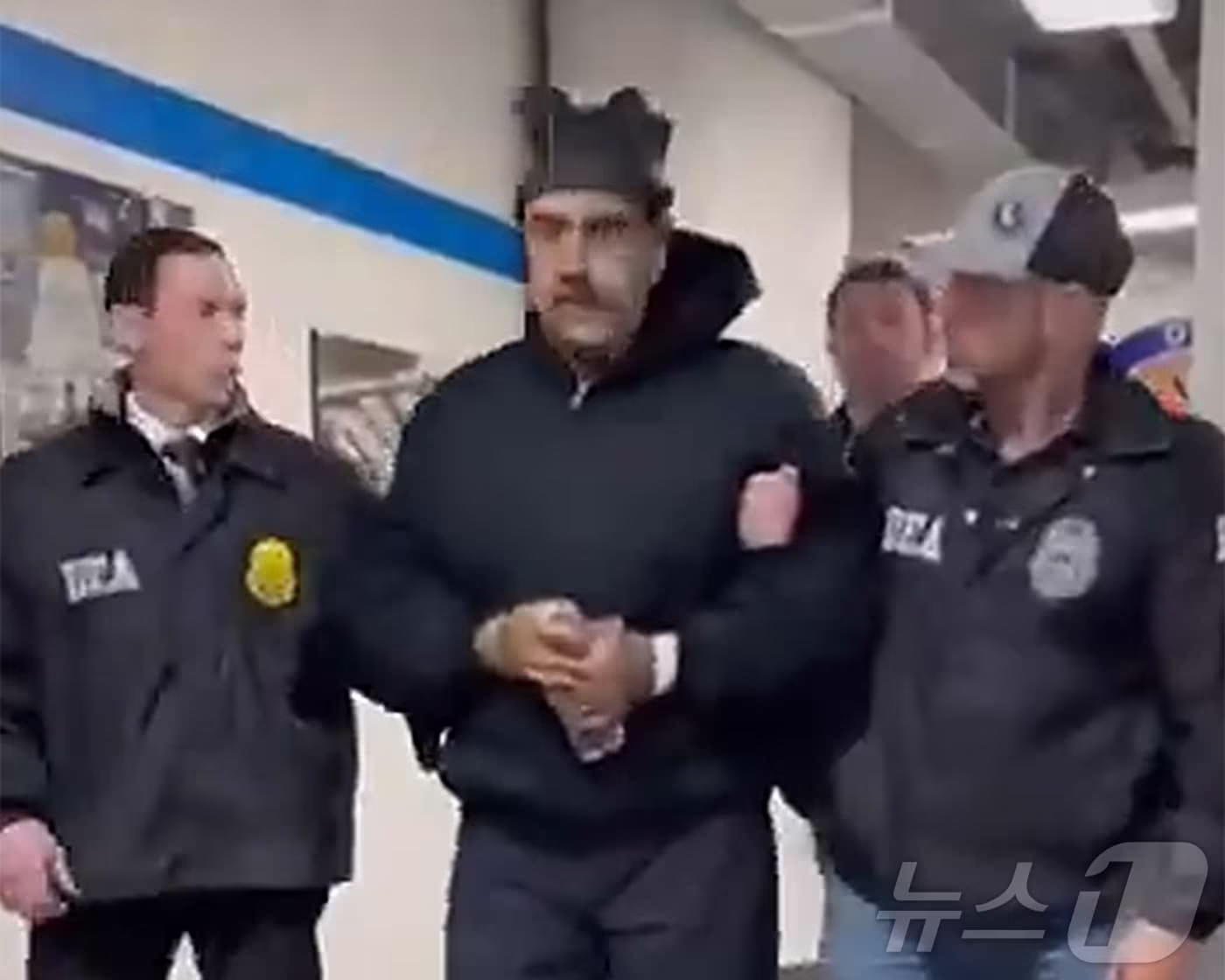 본문 이미지 - 니콜라스 마두로 베네수엘라 대통령이 3일(현지시간) 미국 마약단속국(DEA) 요원에게 이끌려 '퍼프 워크'(perp walk·수사기관이 피의자를 언론 카메라에 의도적으로 노출시키는 행위)를 하는 모습이 공개됐다. (백악관 긴급대응 엑스 계정 게시물 캡쳐) 2026.1.4/뉴스1
