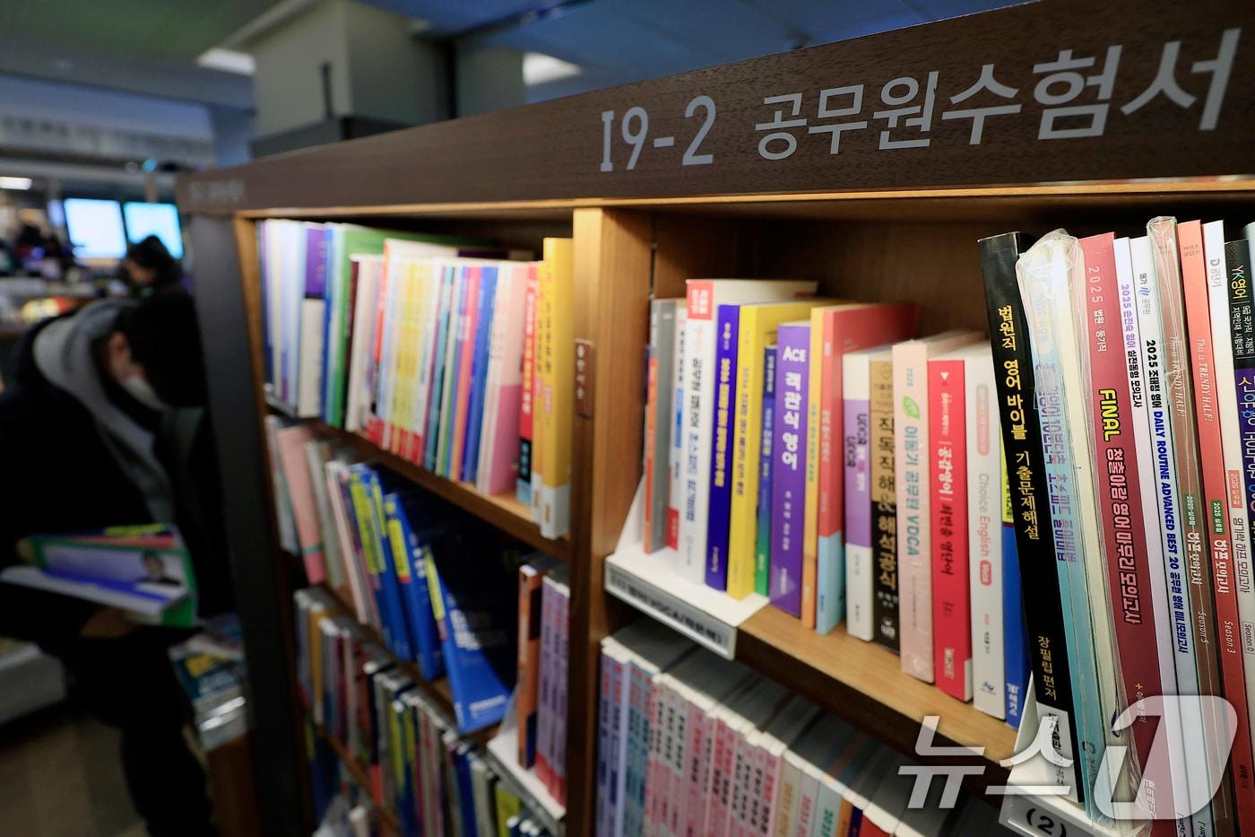 본문 이미지 - 정부의 공무원 채용 규모 확대 및 처우 개선 등으로 공무원 시험 시장이 꿈틀대는 가운데 지난 4일 서울 광화문 교보문고를 찾은 공시생이 수험서를 살펴보고 있다.  2026.1.4/뉴스1 ⓒ News1 박정호 기자