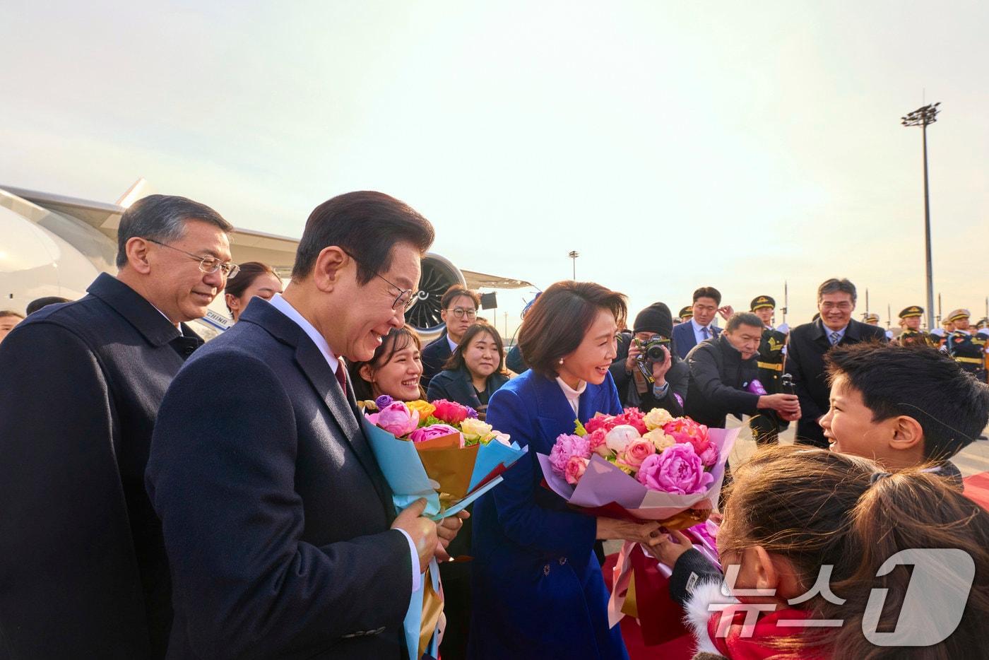 중국을 국빈방문하는 이재명 대통령과 김혜경 여사가 4일 베이징 서우두 공항에서 화동들에게 꽃다발을 전달 받고 있다. (공동취재) 2026.1.4/뉴스1 ⓒ News1 허경 기자