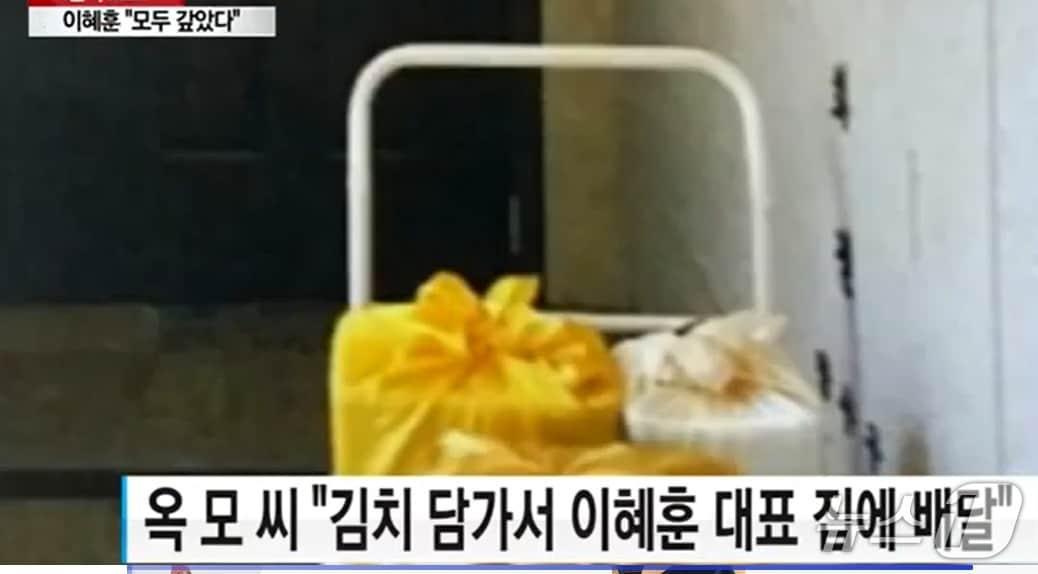 본문 이미지 -  여성 사업가 옥 모 씨는 2017년 9월 당시 이혜훈 바른정당 대표에게 김치 , 명품 등을 선물했다며 이 대표 현관에 갖다 놓은 김치 보따리를 찍은 영상을 공개했다. (YTN 갈무리 ⓒ 뉴스1