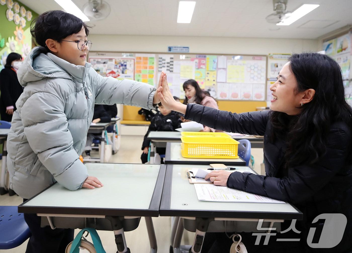 본문 이미지 - 2026학년도 대구지역 공립초등학교 신입생 예비소집이 시작된 5일 오전 대구 동구 팔공초등학교에서 예비 초등학생이 담당 교사와 손바닥을 맞대며 인사를 나누고 있다.(사진은 기사와 무관 2026.1.5 ⓒ 뉴스1 공정식 기자