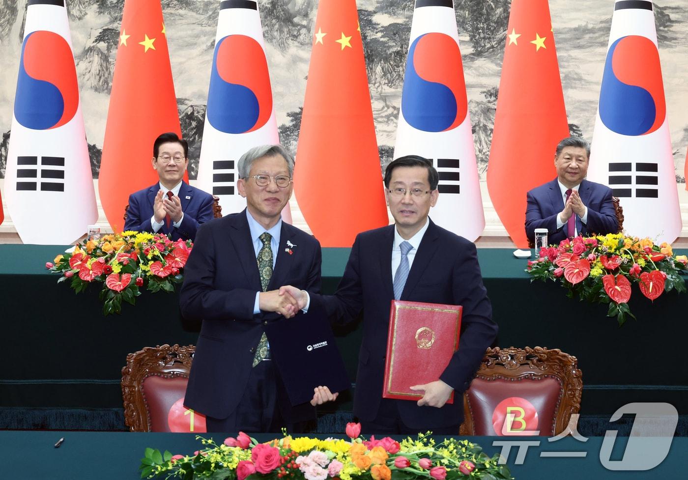 유홍준 국립중앙박물관장(왼쪽)과 라오취안 중국 국가문물국 국장이 5일 베이징 인민대회당에서 이재명 대통령과 시진핑 국가주석이 참석한 가운데 각각 중국 청대 석사자상 한 쌍 기증 증서를 작성한 뒤 기념촬영을 하고 있다. 2026.1.5/뉴스1 ⓒ News1 허경 기자