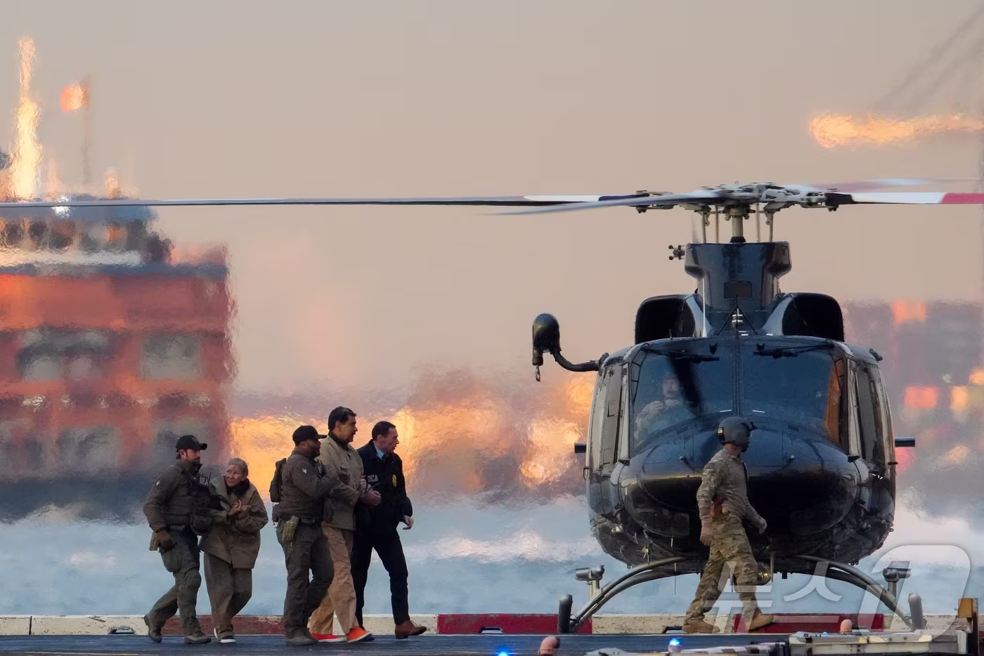 본문 이미지 - 니콜라스 마드로 베네수엘라 대통령과 부인 실리아 플로레스가 5일(현지시간) 미국 뉴욕 맨해튼에 도착한 헬기에서 내려 마약단속국(DEA) 요원들에 의해 연방 법원으로 호송되고 있다. 2026. 01.05. ⓒ 로이터=뉴스1 ⓒ News1 류정민 특파원