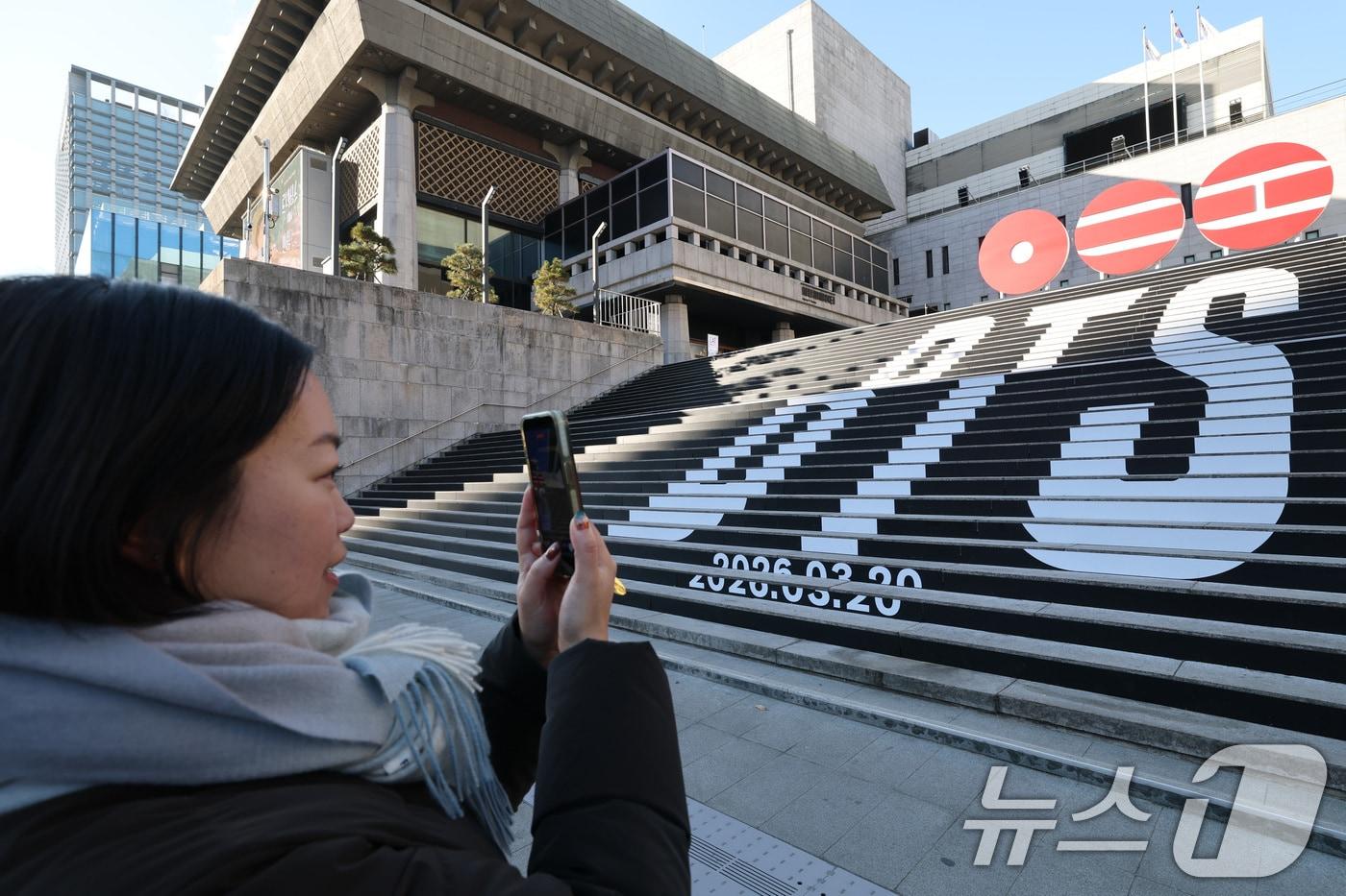 본문 이미지 - 6일 오전 서울 종로구 세종문화회관 야외 계단에 설치된 BTS(방탄소년단)의 컴백 로고 조형물 앞에서 관광객이 기념촬영을 하고 있다. 2026.1.6 ⓒ 뉴스1 임세영 기자