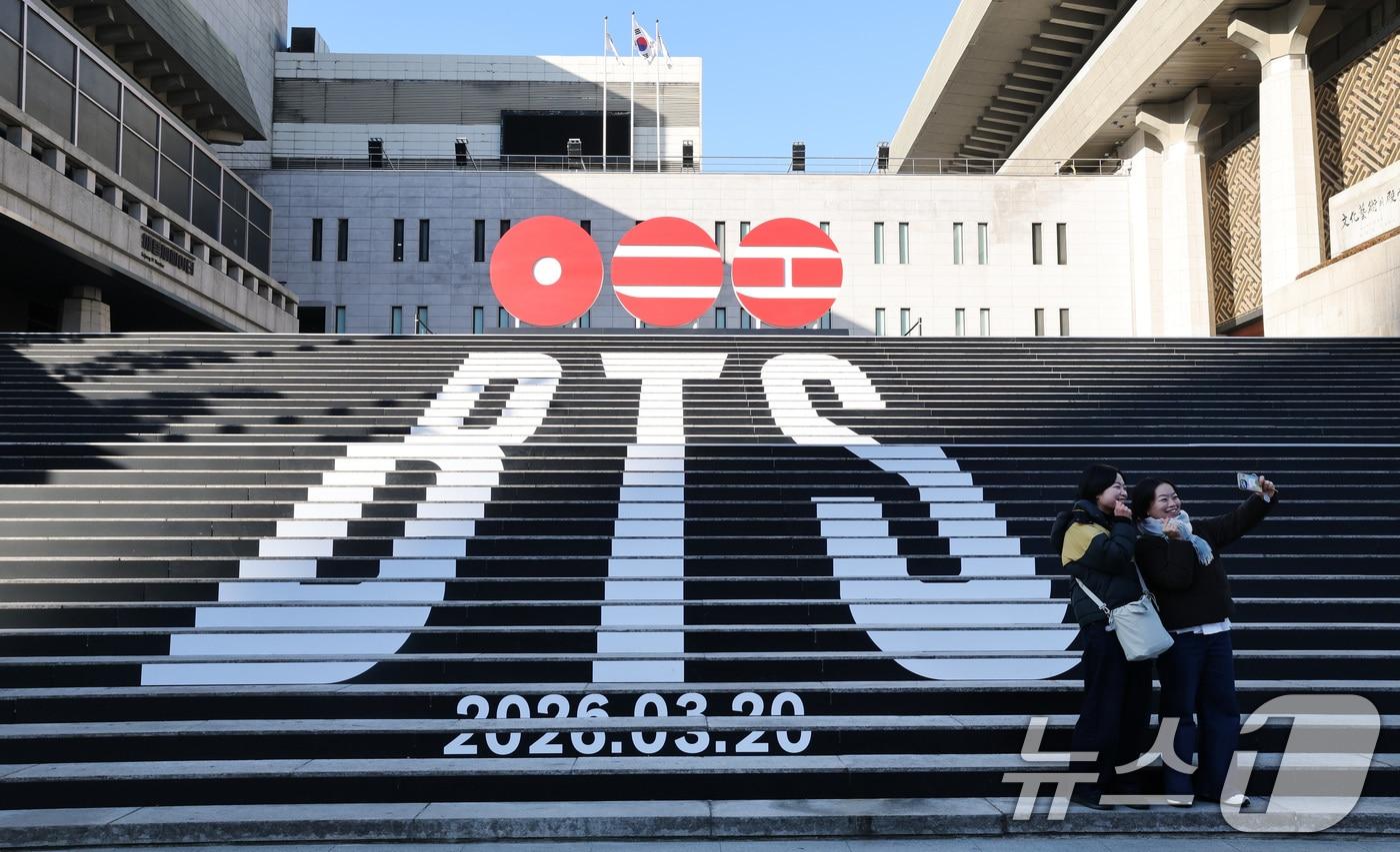 6일 오전 서울 종로구 세종문화회관 야외 계단에 설치된 BTS(방탄소년단)의 컴백 로고 조형물 앞에서 관광객들이 기념촬영을 하고 있다. BTS는 3월 20일 컴백과 새 앨범 발매, 월드투어 일정을 공식 발표했다. 2026.1.6/뉴스1 ⓒ News1 임세영 기자