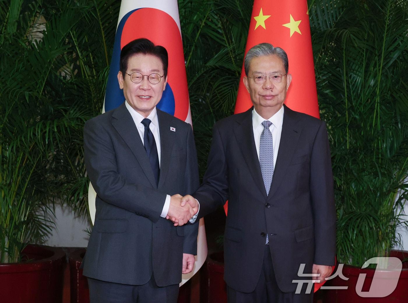 본문 이미지 - 중국을 국빈방문 중인 이재명 대통령이 6일 베이징 인민대회당에서 자오러지 전국인민대표대회 상무위원장과 악수하고 있다. 2026.1.6/뉴스1 ⓒ News1 허경 기자