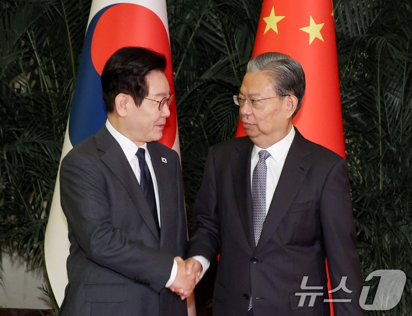 본문 이미지 - 중국을 국빈방문 중인 이재명 대통령이 6일 베이징 인민대회당에서 자오러지 전국인민대표대회 상무위원장과 악수하고 있다. 2026.1.6/뉴스1 ⓒ News1 허경 기자