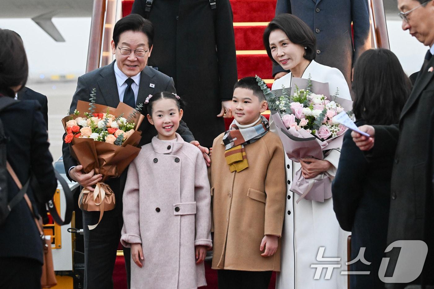 이재명 대통령과 부인 김혜경여사가 6일 중국방문 두번째 도시인 상하이 푸동 국제공항 도착해 영접나온 화동과 기념사진을 찍고 있다. 2026.1.6/뉴스1 ⓒ News1 허경 기자