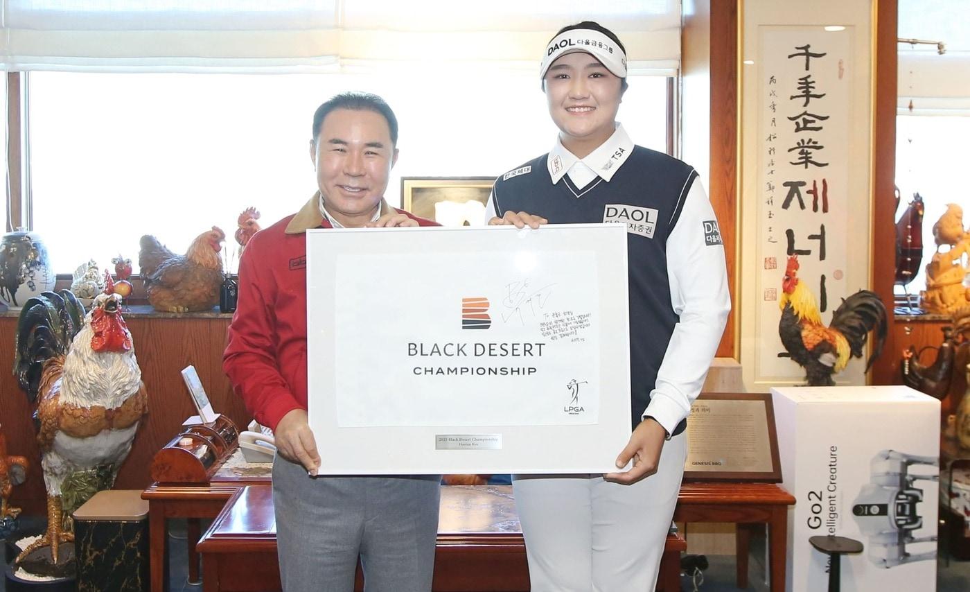 BBQ 후원 LPGA 스타 유해란 선수가 지난해 우승한 블랙데저트 대회 당시 우승 홀 깃발에 사인과 다짐을 적어 윤홍근 회장에게 전달했다.(BBQ 제공)