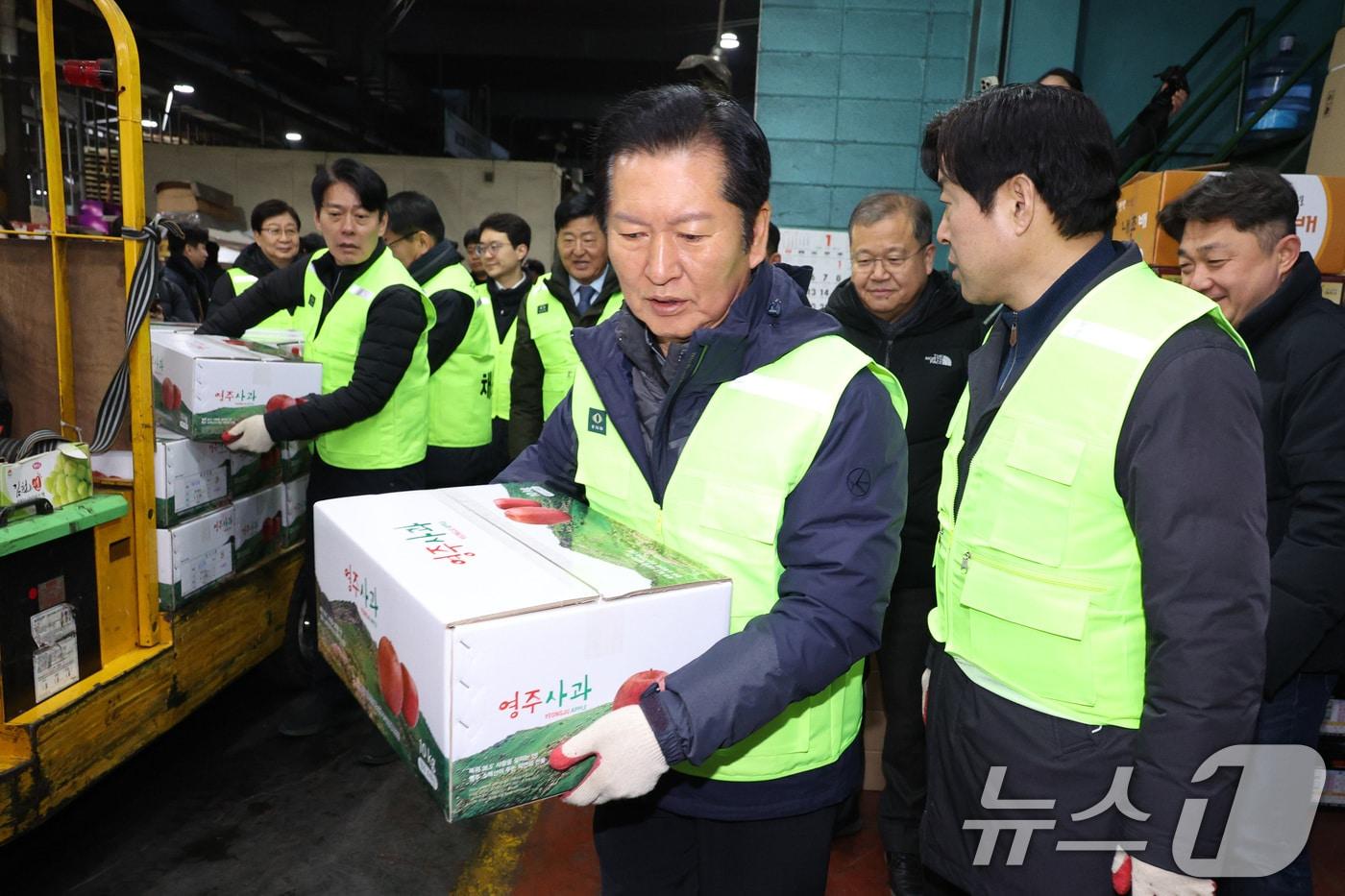 정청래 더불어민주당 대표가 7일 서울 송파구 가락동 농수산물 종합도매시장을 찾아 낙찰 받은 과일을 옮기고 있다. 2026.1.7/뉴스1 ⓒ News1 신웅수 기자